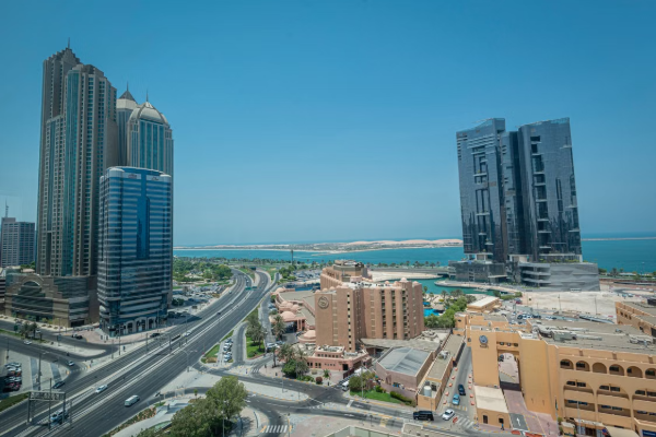 Aerial view of a modern Abu Dhabi cityscape with high-rise buildings by the sea