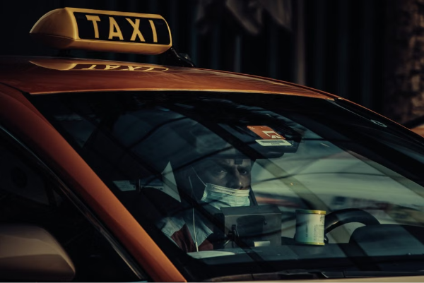 Close-up of a masked taxi driver in Dubai, highlighting public transport during pandemic times