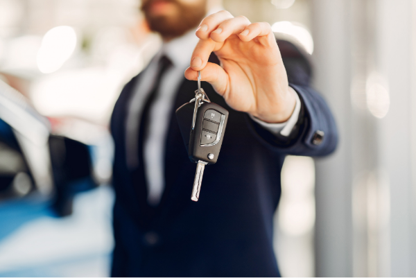 An agent handing keys to the car rental