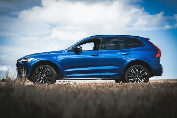 blue Volvo XC60 on brown grass field under white clouds and blue sky during daytime